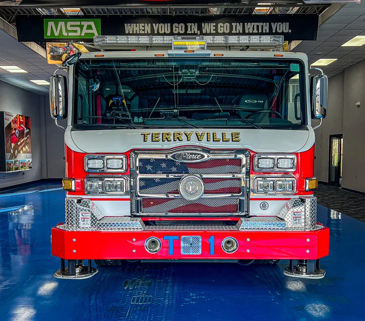 Head-on front view showing grille, bumper, and warning light bar