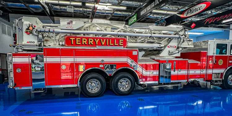 Driver-side full profile view showing tandem axle layout and side body compartments