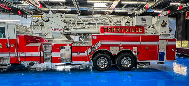Officer-side full profile view showing side body panels and aerial ladder bed