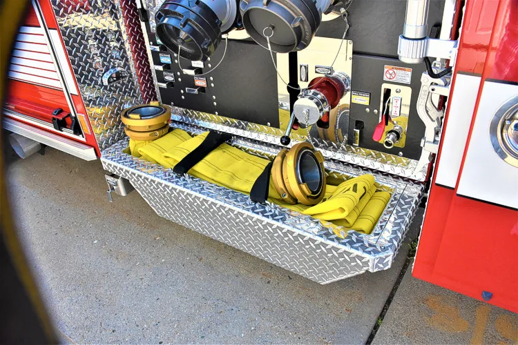 Open lower side compartment showing pump plumbing and intake fittings