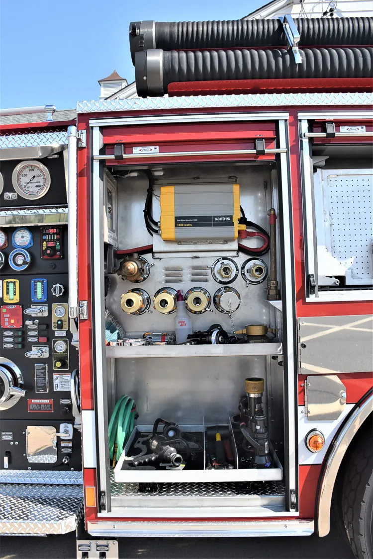 Open rear-side compartment showing panel controls and hose connections