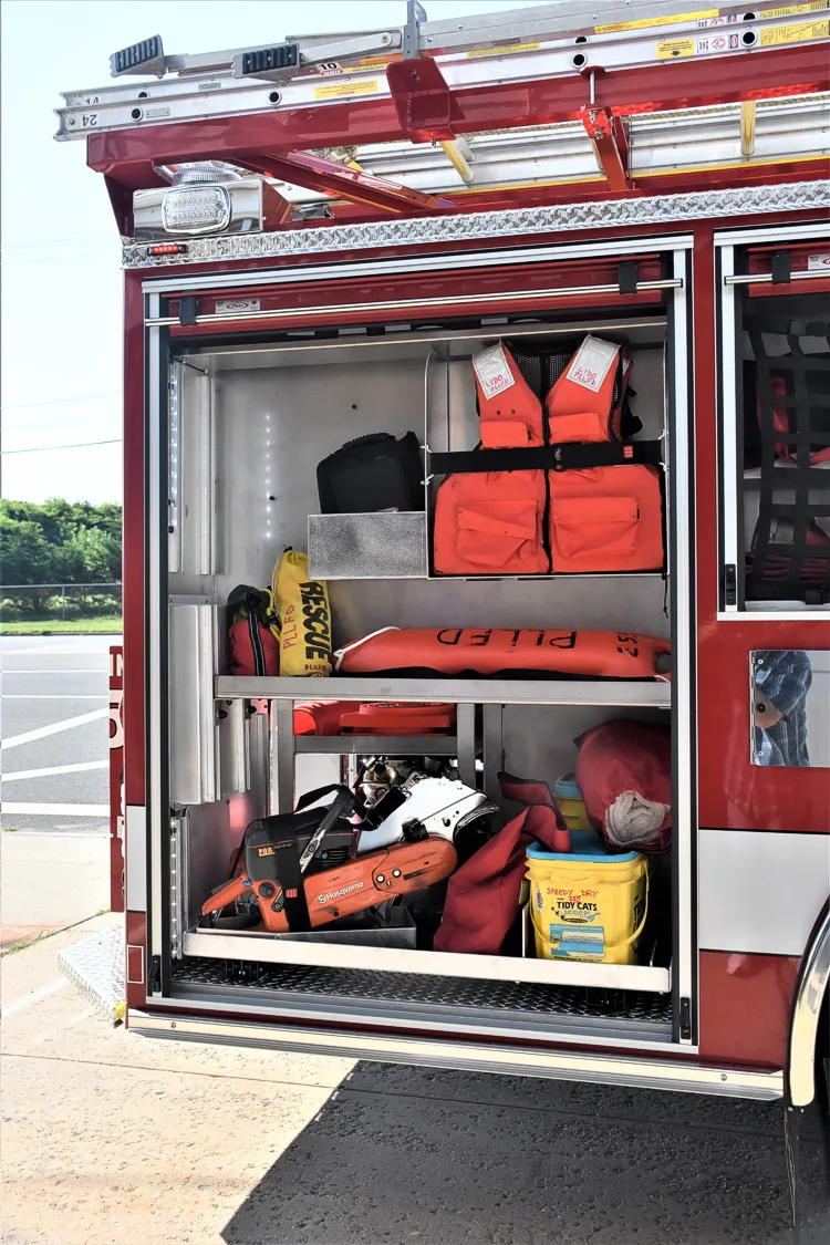 Open side compartment showing bags, cones, and shelf-mounted equipment