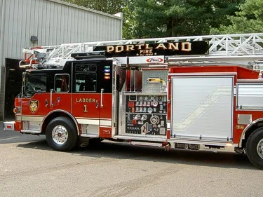 Left-side midsection close-up showing pump panel controls, gauges, and adjacent roll-up compartments.