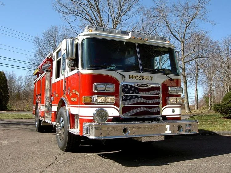 Front-left exterior close view showing grille, bumper, and warning lights
