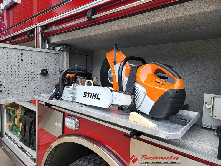 Open side compartment showing power saw and equipment storage bins