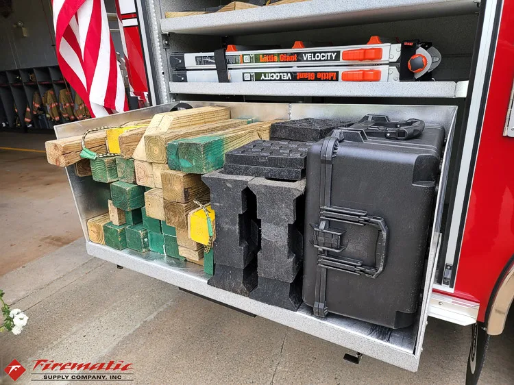 Open side compartment showing battery cases and utility storage bins