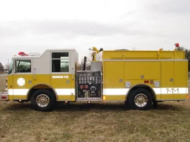 Driver-side profile view with pump panel controls and long side body compartments