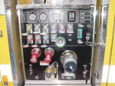 Pump panel close-up showing gauges, levers, intake valves, and discharge outlets