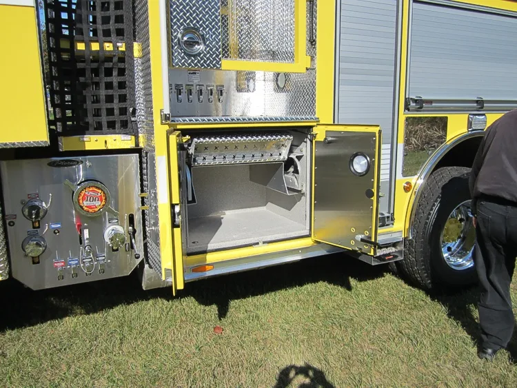 Open lower side compartment showing shelf storage and equipment bay