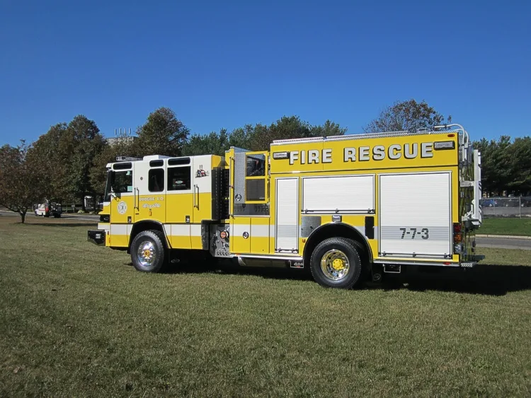 Rear-left exterior view showing side body, chevrons, and warning lights
