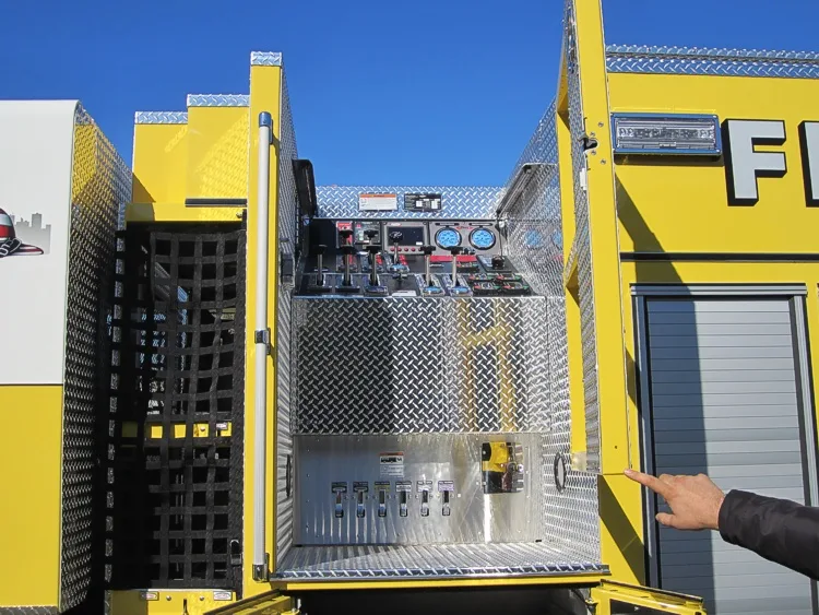 Rear crew-side body view showing open access door and side storage racks