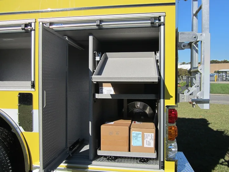 Open side compartment showing empty bay and stacked cardboard boxes