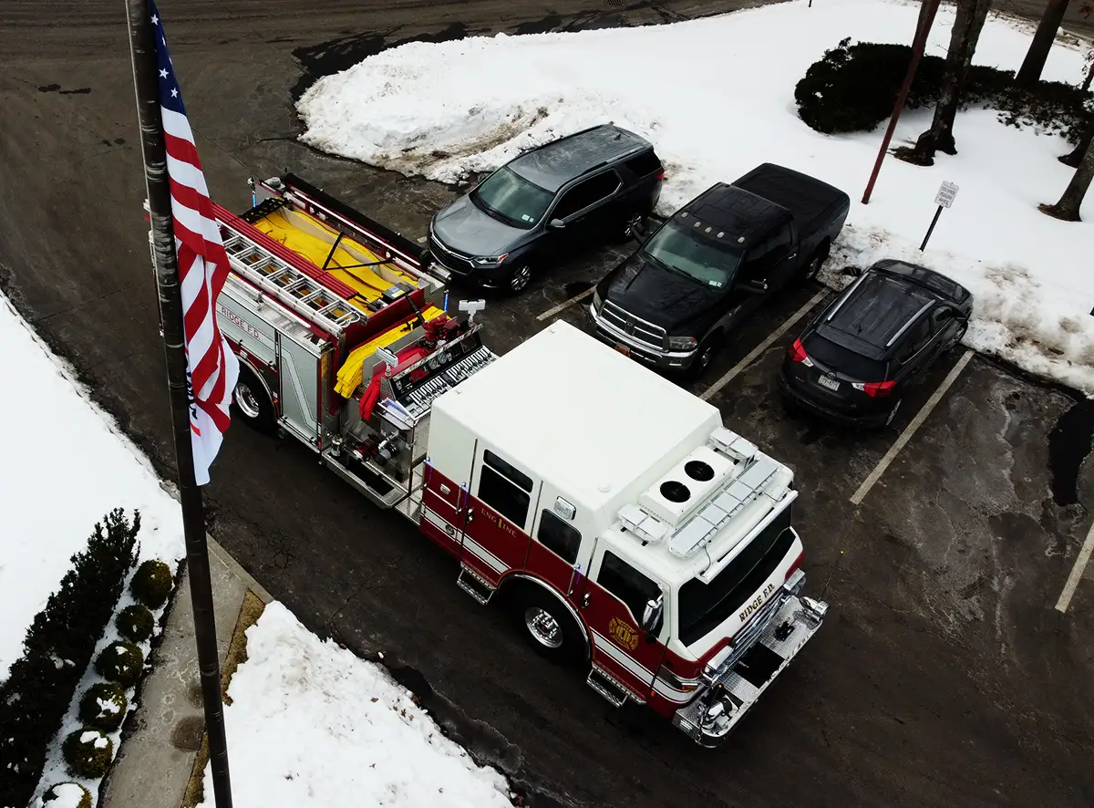 Aerial top-down front-left view showing cab roof, hosebed, and body layout