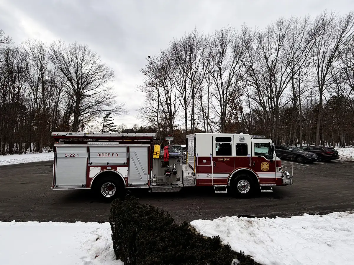 Rear-right exterior view showing side body, rear wheels, and upper hosebed