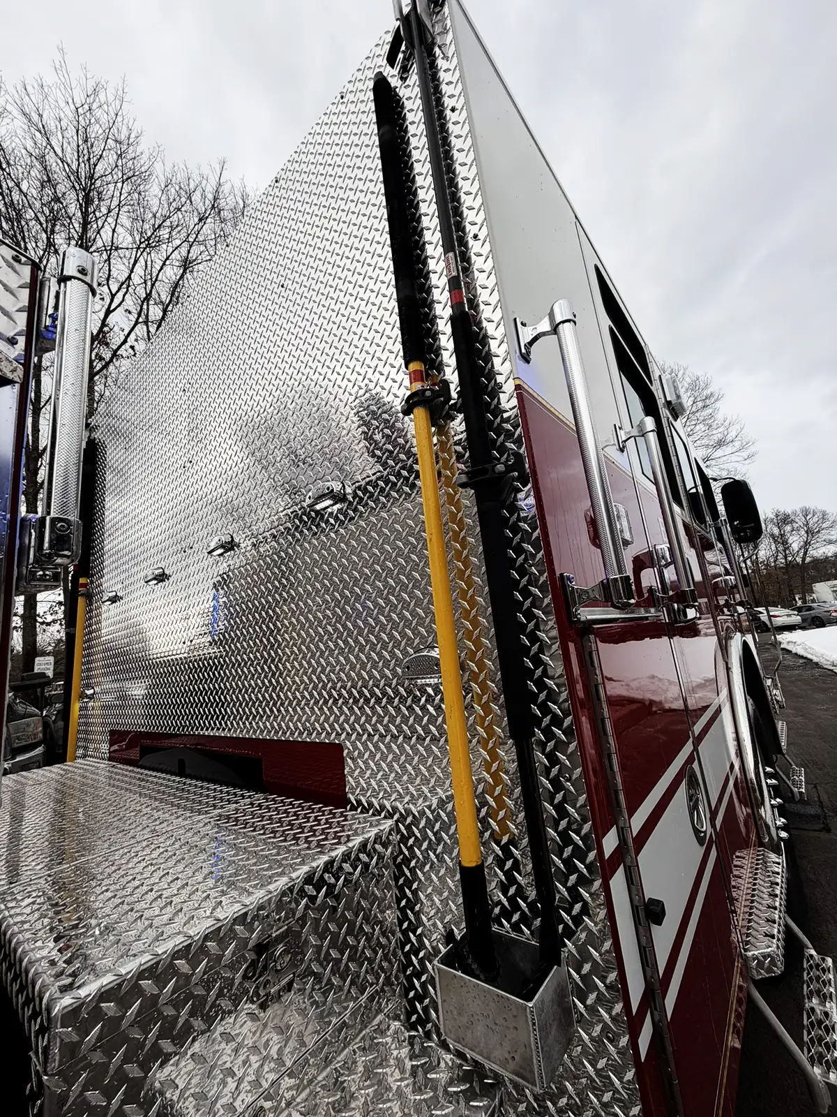 Rear-side vertical compartment showing long-handled tools and storage slots