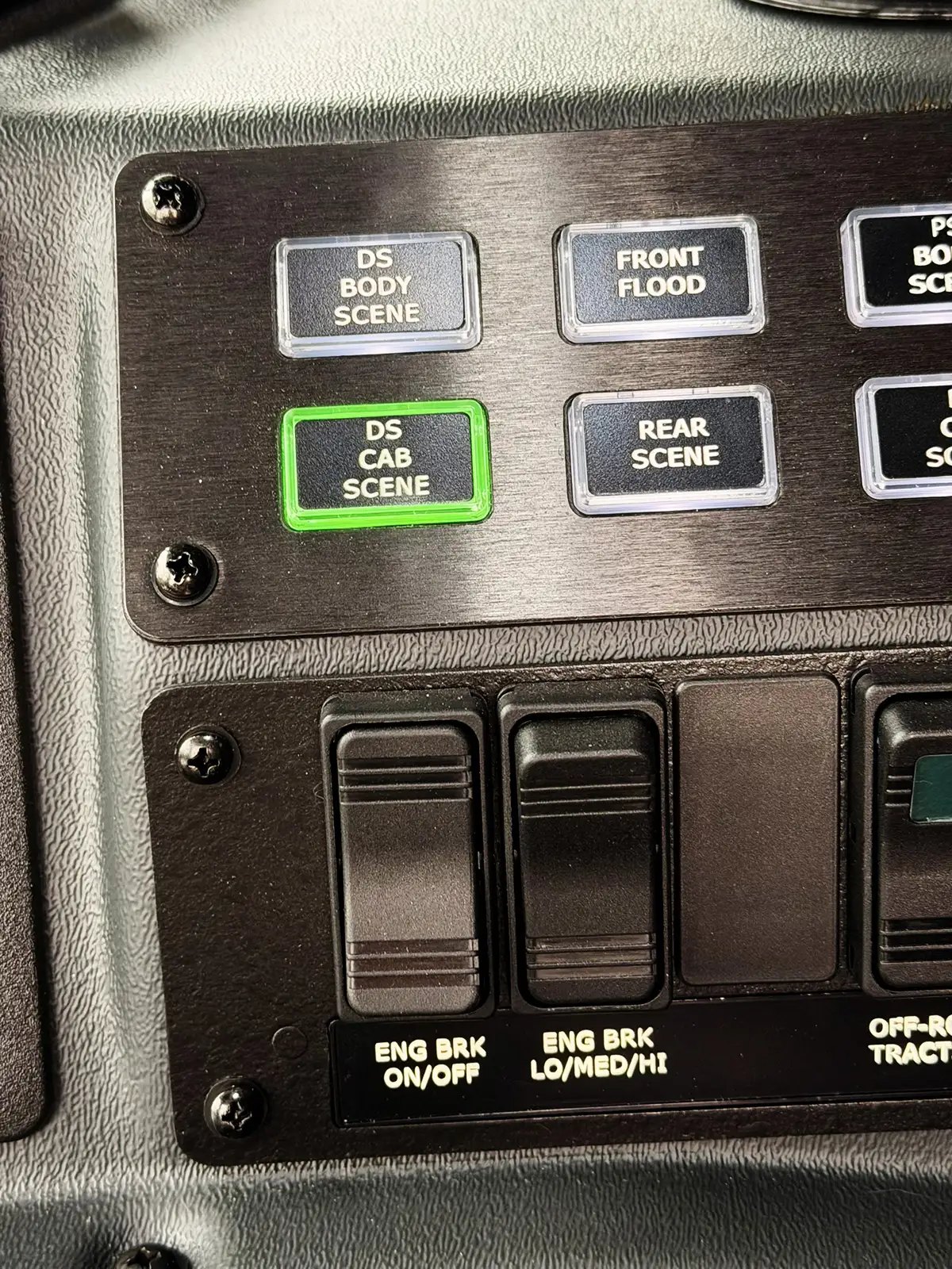 Cab switch panel close-up with illuminated button and labeled controls
