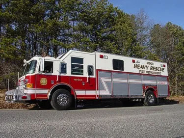 Heavy rescue truck side profile parked in front of trees and roadside
