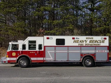 Heavy rescue truck side profile parked roadside with trees in background