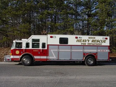 Heavy rescue truck side profile showing long body and roof-mounted rails