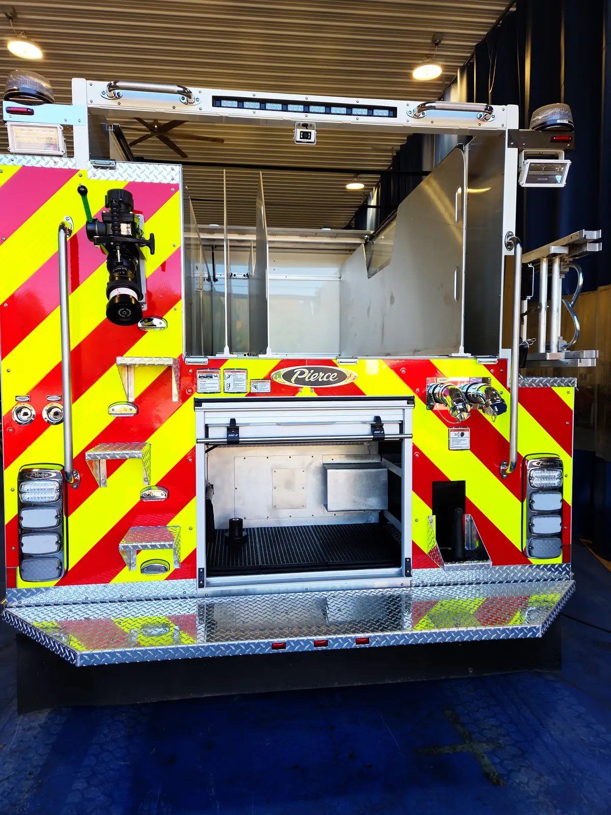 Rear view showing chevron striping, open hosebed area, and lower rear compartment