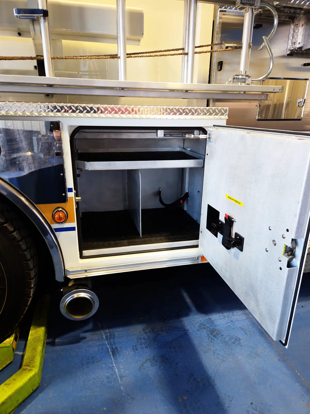 Open side compartment near rear wheel showing shelf divider and lower storage bay