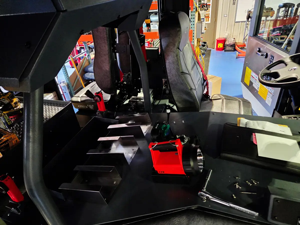 Cab interior view showing center console, front seats, and mounted flashlights