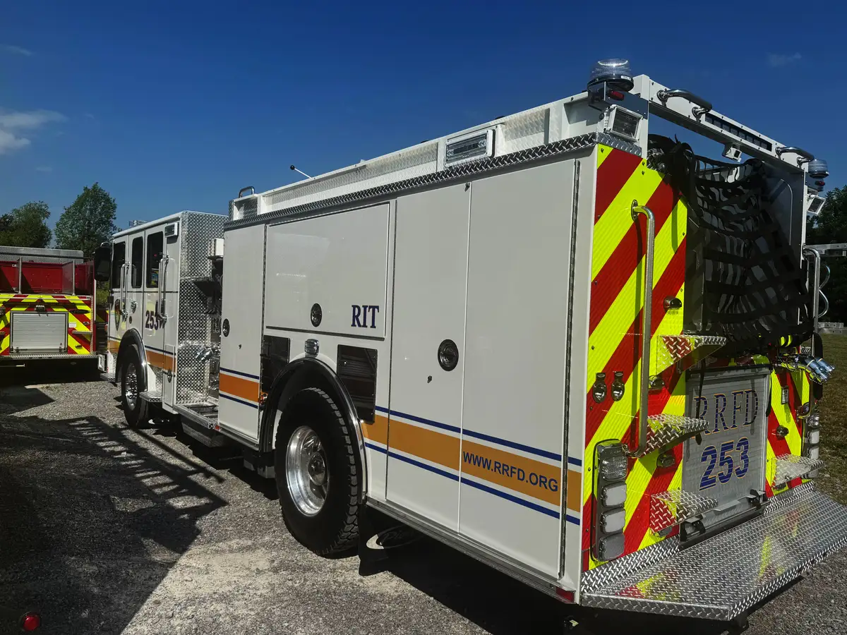 Rear-right exterior view showing side compartments, rear chevrons, and hosebed netting