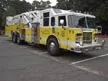 Aerial ladder truck front-left exterior view showing cab and ladder bed