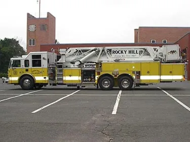 Driver-side full profile showing ladder bed and tandem rear axles