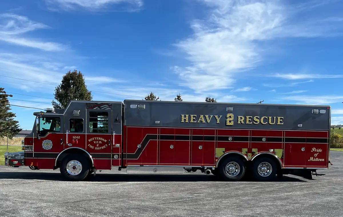 Driver-side full profile showing long body and tandem rear wheels