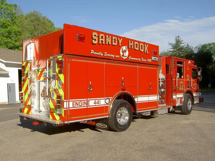 Rear-right exterior view showing chevrons, rear step, and side compartments