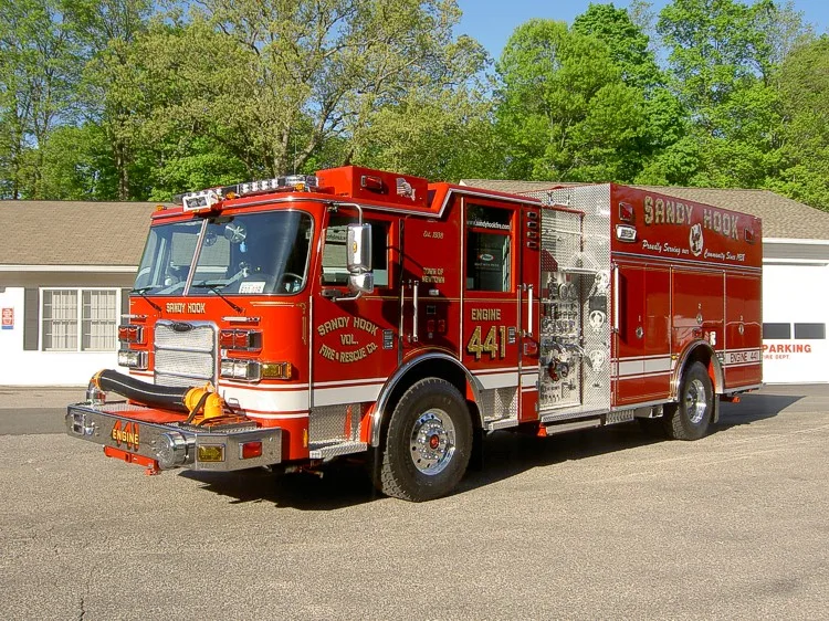 Rescue pumper front-left profile showing side compartments and roof warning lights