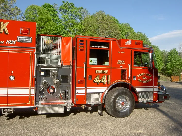 Driver-side view showing pump controls, open cab door, and wheel area