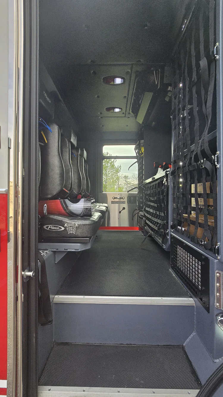 Rear crew area interior view showing bench seats, SCBA mounts, and side storage racks