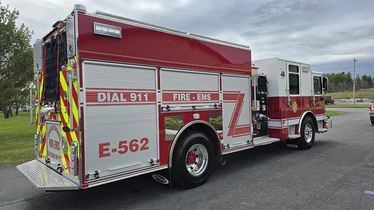 Pumper rear-right exterior view showing side roll-up doors, rear chevrons, and hosebed netting