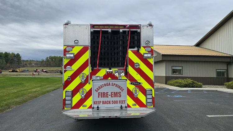 Rear view showing chevron striping, hosebed netting, and rear discharge connections