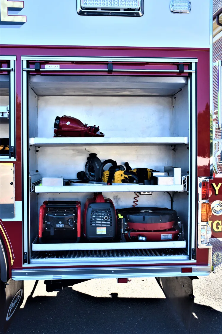 Open rear compartment showing shelving with bags, bins, and stored equipment