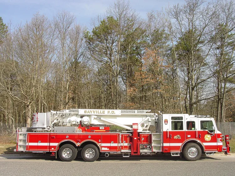 Driver-side full profile showing the stowed aerial ladder, side body compartments, and tandem rear wheels.