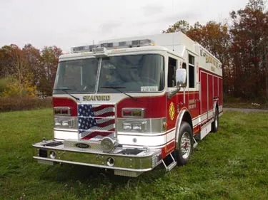 Rescue pumper front-left angle showing bumper, grille, and side body compartments