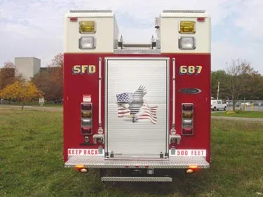 Rear view showing rear door, warning lights, and lower hose connection points