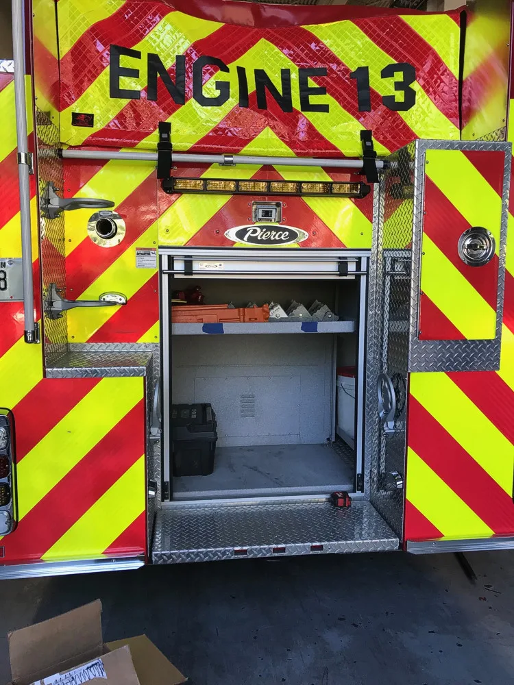 Rear view showing red-and-yellow chevrons and open rear center compartment