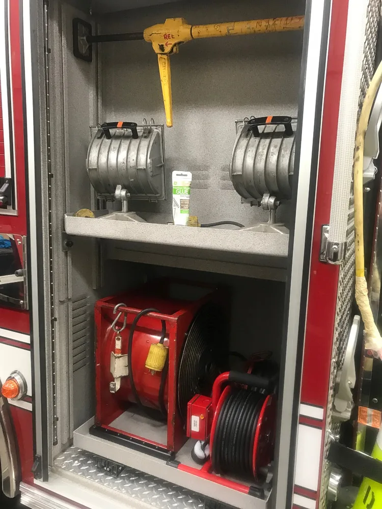 Open side compartment showing extinguisher and lower storage bay