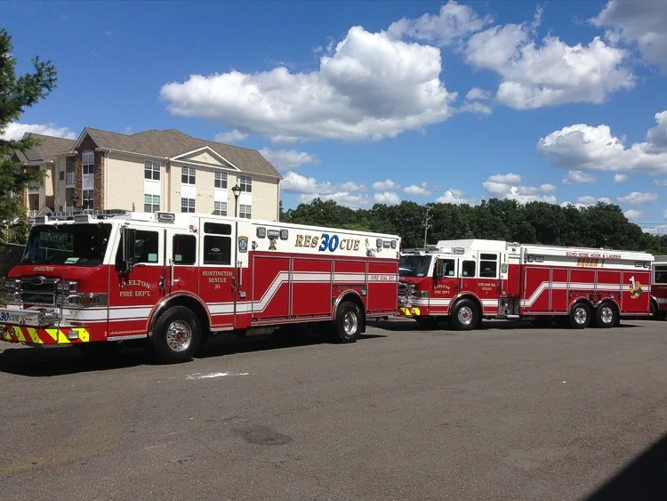 Two-apparatus side lineup view showing long rescue bodies and wheel areas