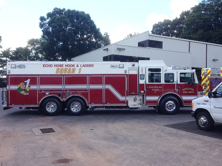 Driver-side full profile showing tandem rear axles and rescue compartments