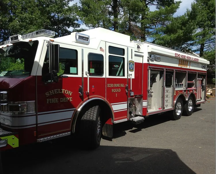 Front-left exterior view with open side compartments showing equipment storage