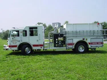 Driver-side profile view showing side pump panel, tank body, and wheel area