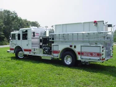 Driver-side rear three-quarter view showing pump controls and tank body compartments