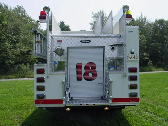 Rear exterior view showing rear door, ladder rack, and warning lights