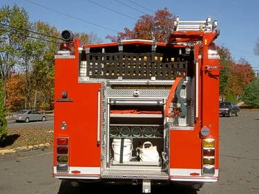 Rear view with open hosebed section showing hose storage channels and rear step