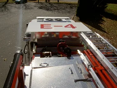 Overhead hosebed view showing red deck gun and ladder rails